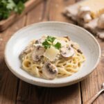 creamy mushroom pasta with parmesan and parsley in a white bowl
